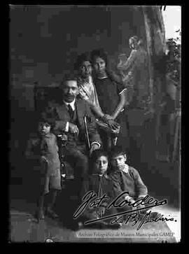 Foto de estudio de un padre sentado en medio de sus cinco hijos