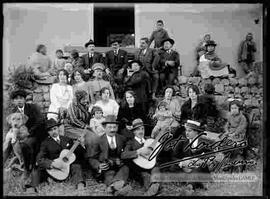 Familia en el patio de una casa, con un conjunto musical de estudiantina