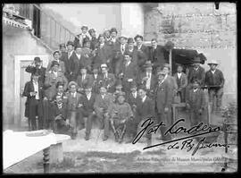 Grupo de empleados en el patio de una casa particular, celebrando un acontecimiento con bebidas