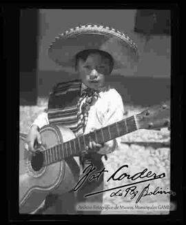 Julio Gonzalo Cordero Benavides, sujetando una guitarra