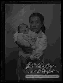 Foto de estudio de una niña sujetando a un bebe