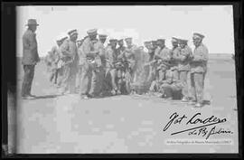 Grupo de soldados, esperando la hora del almuerzo, en el campo de práctica de maniobras