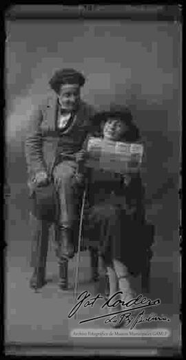 Foto de estudio de una pareja de esposos, observando un folleto del Teatro Victoria