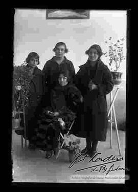 Cuatro señoritas en el interior de una casa. Llevan puesto vestimenta de color negro.